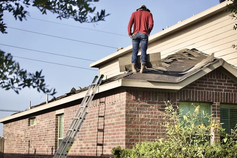Professional roofer working on a residential roof in Snowdenville